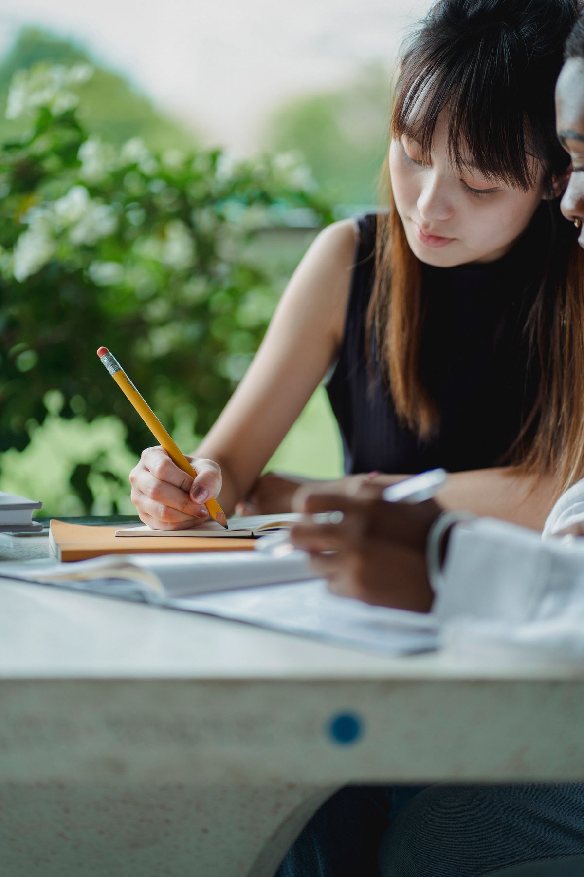 Two young people studying together outdoors