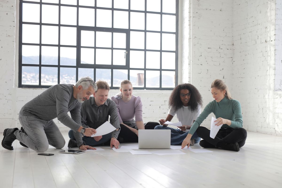 Young professionals collaborating together on the floor of a bright studio